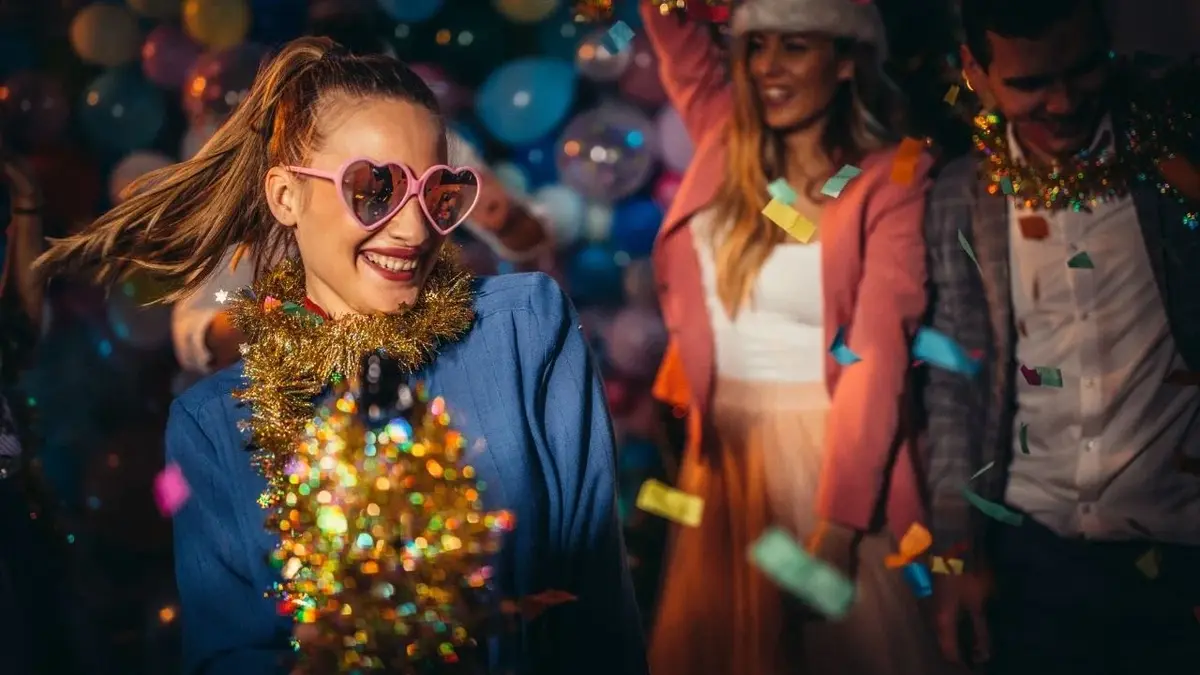 Dziewczyna w okularach-serduszkach bawiąca się na imprezie