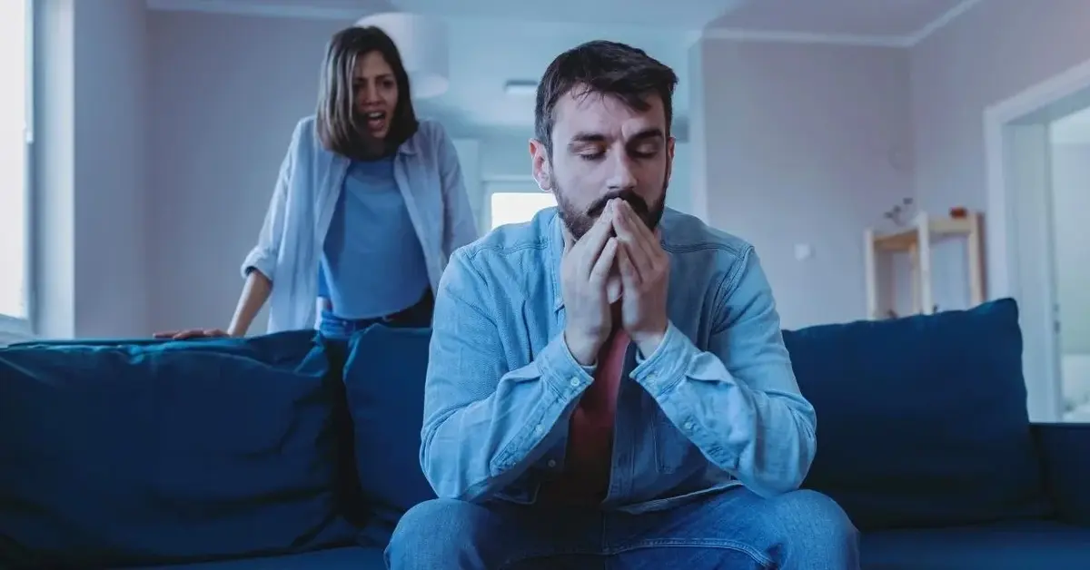 Kobieta krzyczy na mężczyznę. On jest odwrócony do niej plecami, milczy.