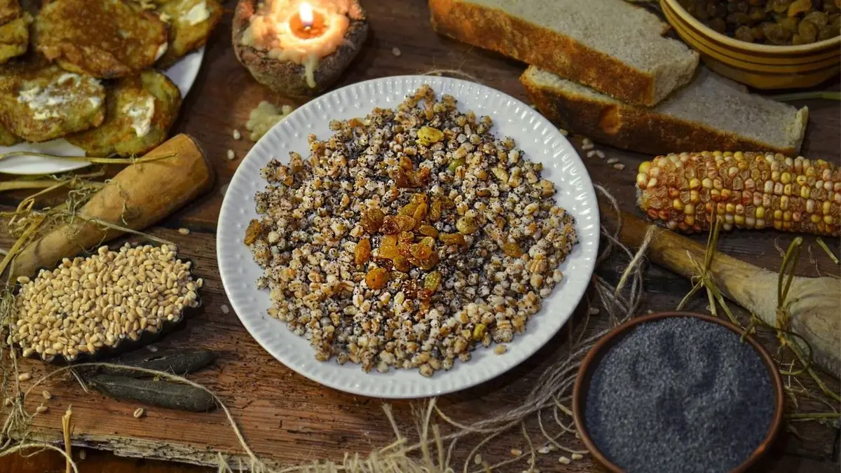 Wigilijna kutia w białej misce na stole w otoczeniu naczyń i akcesoriów kuchennych