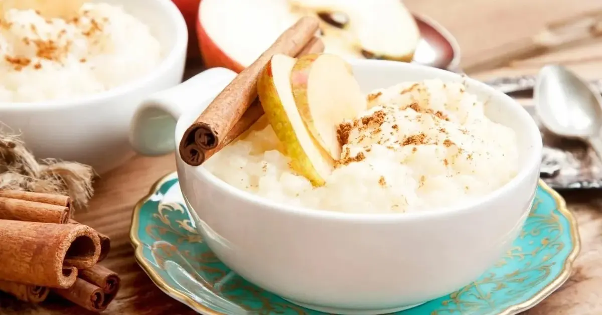 Ryż na mleku posypany cynamonem, z kawałkami jabłek.