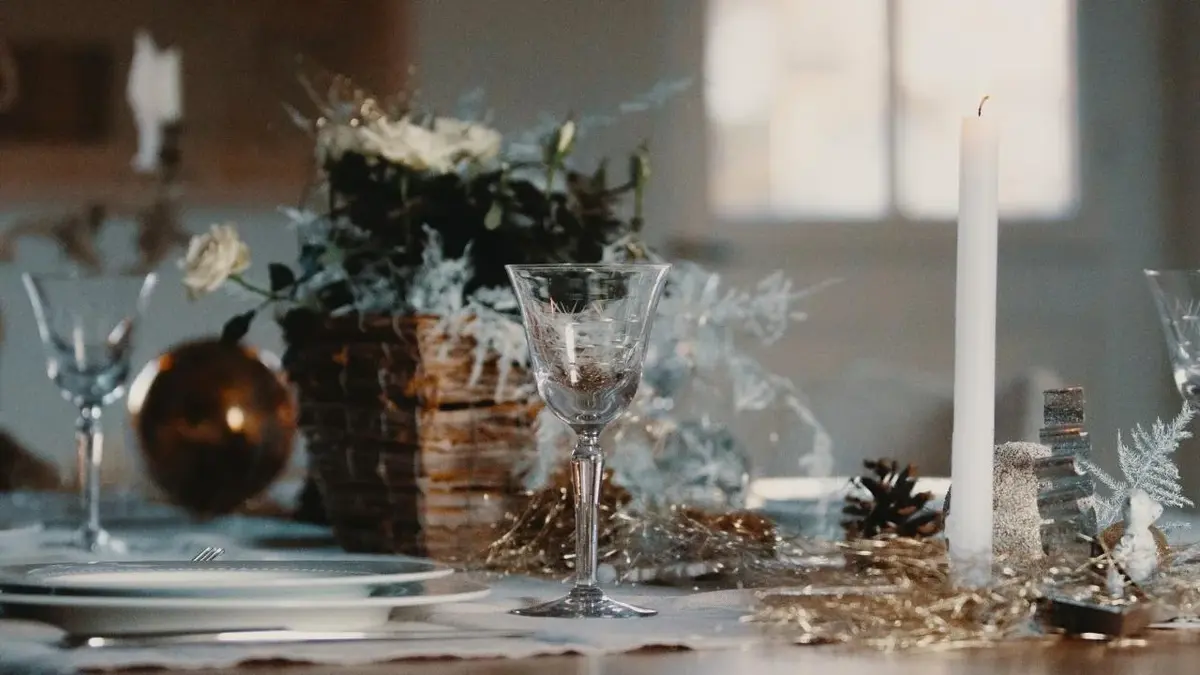 Wigilijne nakrycie stoły. Dekoracje, kieliszki, świeczka.