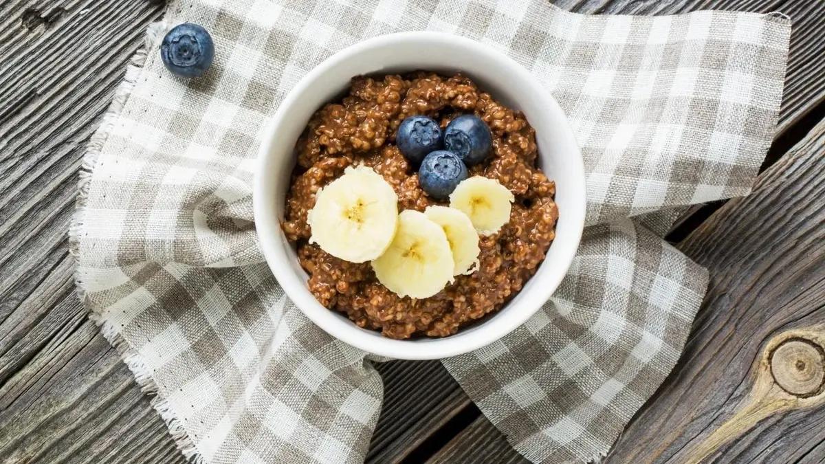 Owsianka czekoladowa udekorowana bananami i borówkami.