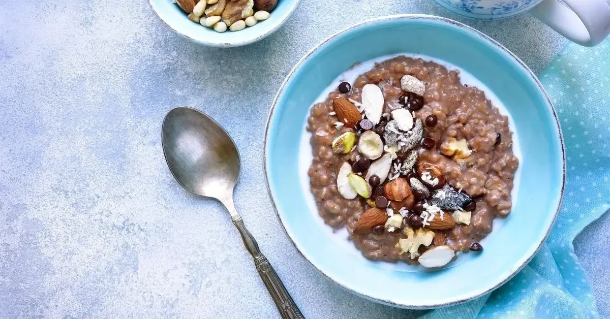 Owsianka czekoladowa udekorowana orzechami i czekoladowymi drażetkami.