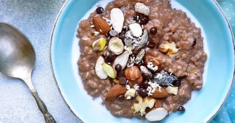Owsianka czekoladowa udekorowana orzechami i czekoladowymi drażetkami.