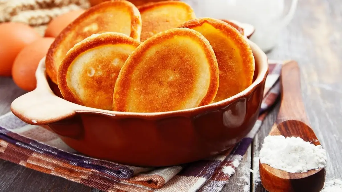 Placuszki bananowe w misce. Obok jajka i mąka.