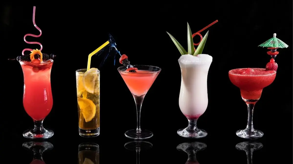 Pucharki i szklanki do drinków wypełnione kolorowymi koktajlami