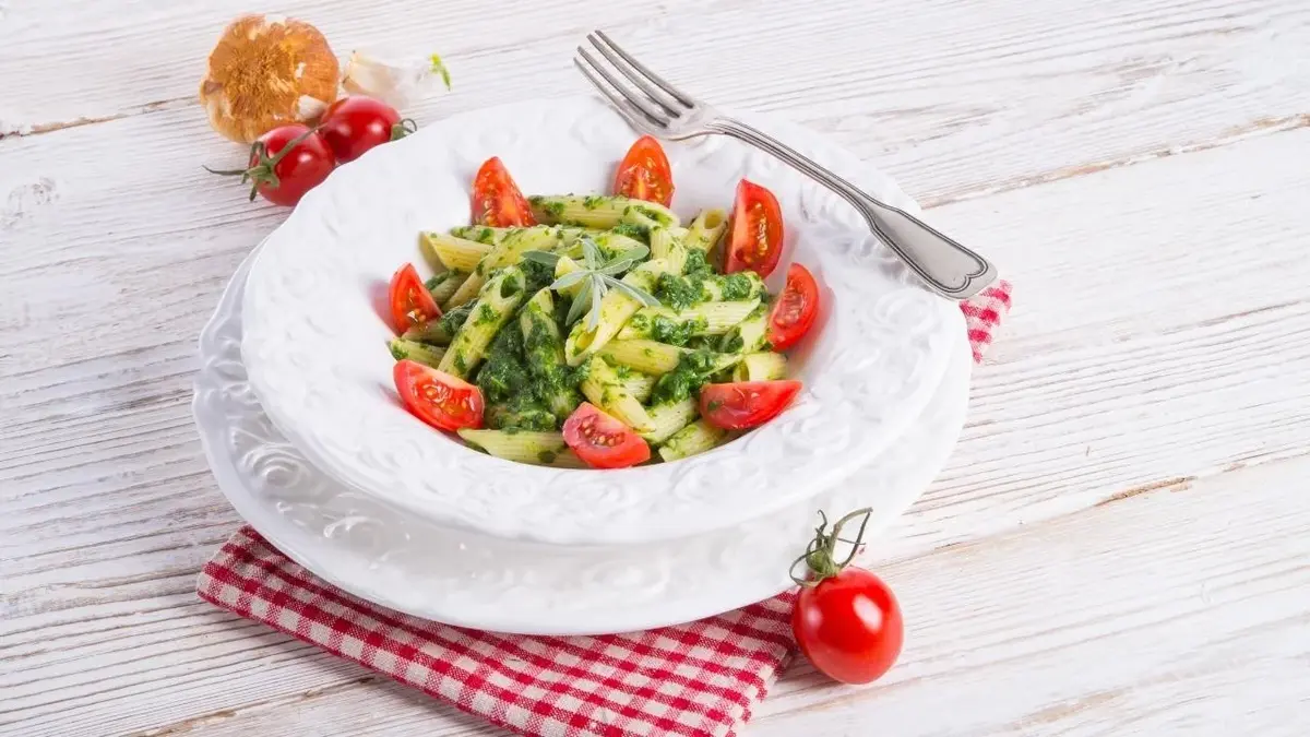 Szpinak z makaronem udekorowany pomidorkami.