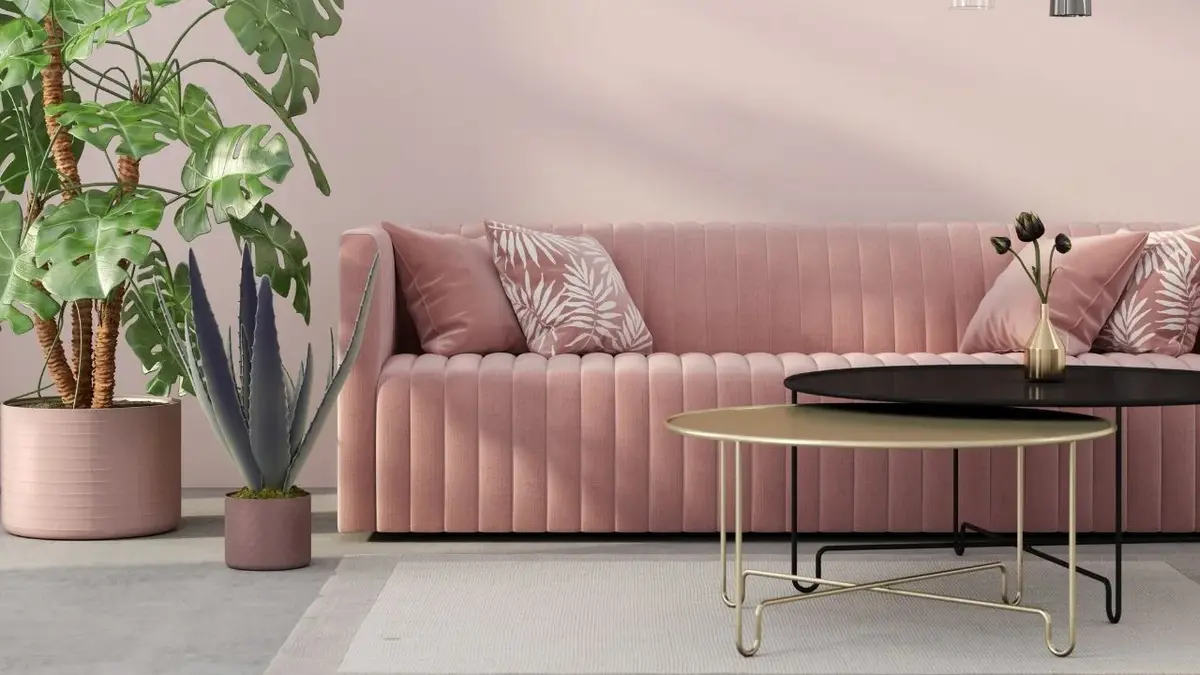 Sofa z różowego weluru i dwa metalowe stoliki kawowe o okrągłym kształcie