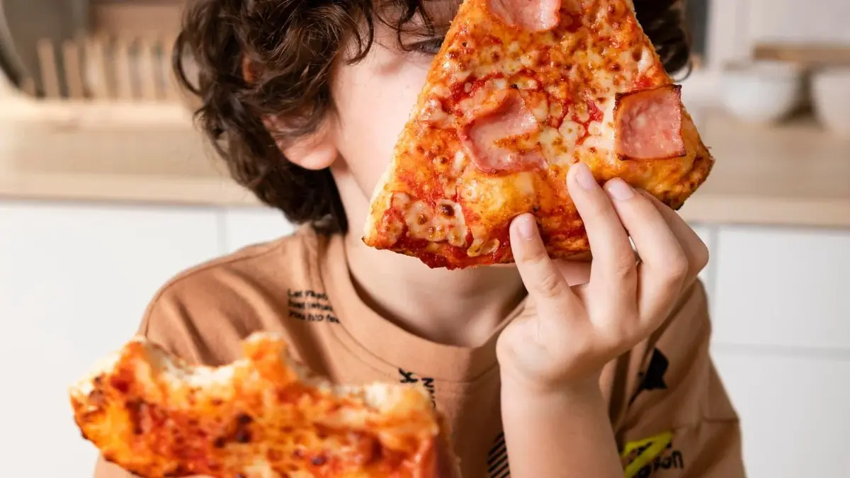 Dziecko je pizzę z bekonem