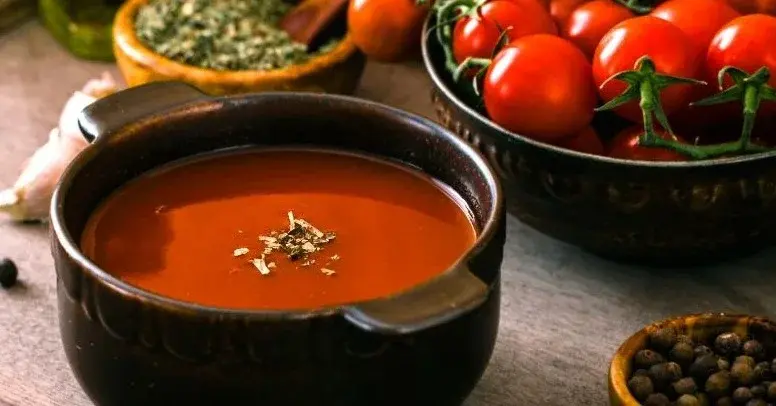 zupa krem z pomidorów w glinianej misce i pomidory koktajlowe