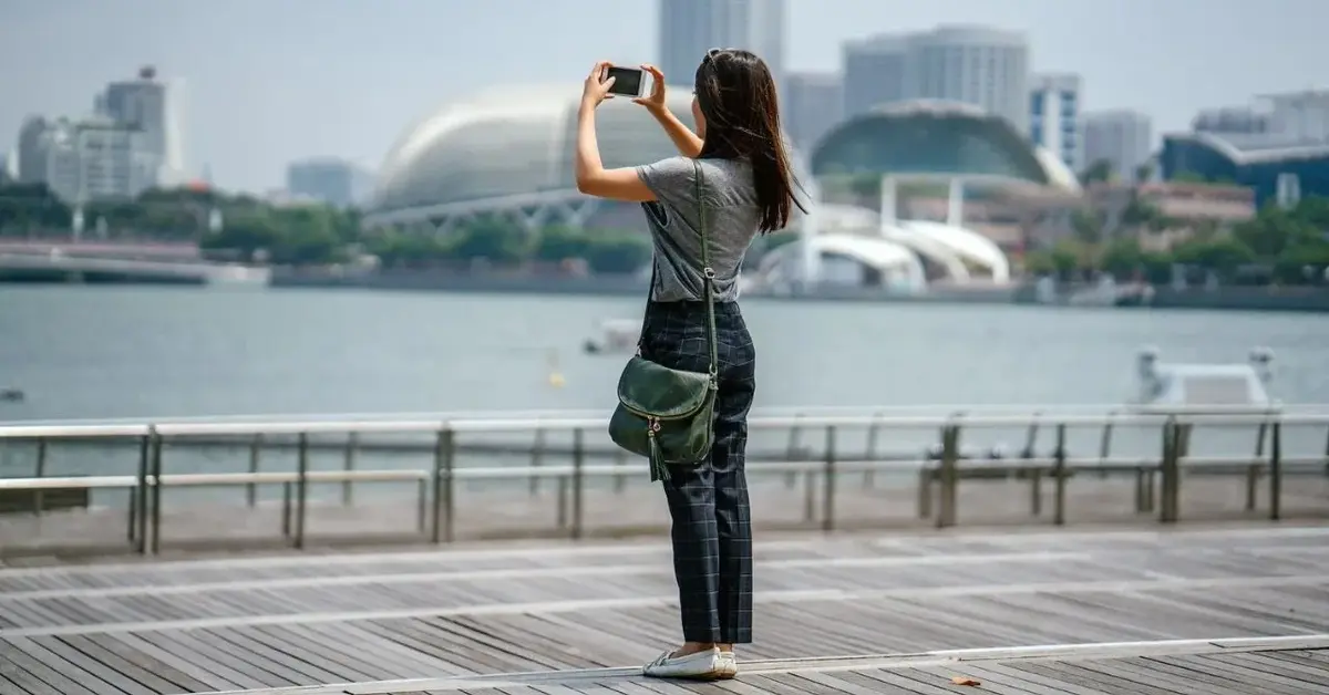 Kobieta w czasie spaceru robi zdjęcie telefonem komórkowym