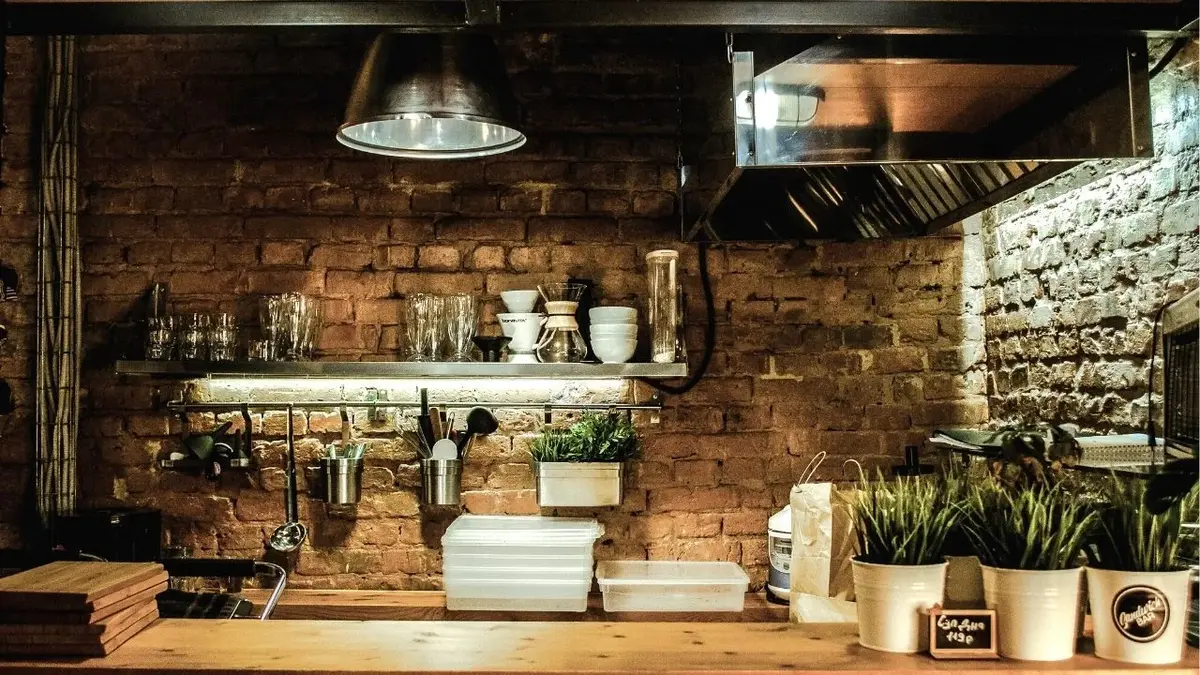Backsplash z cegły w kuchni rustykalnej z półką ścienną i metalową lampą