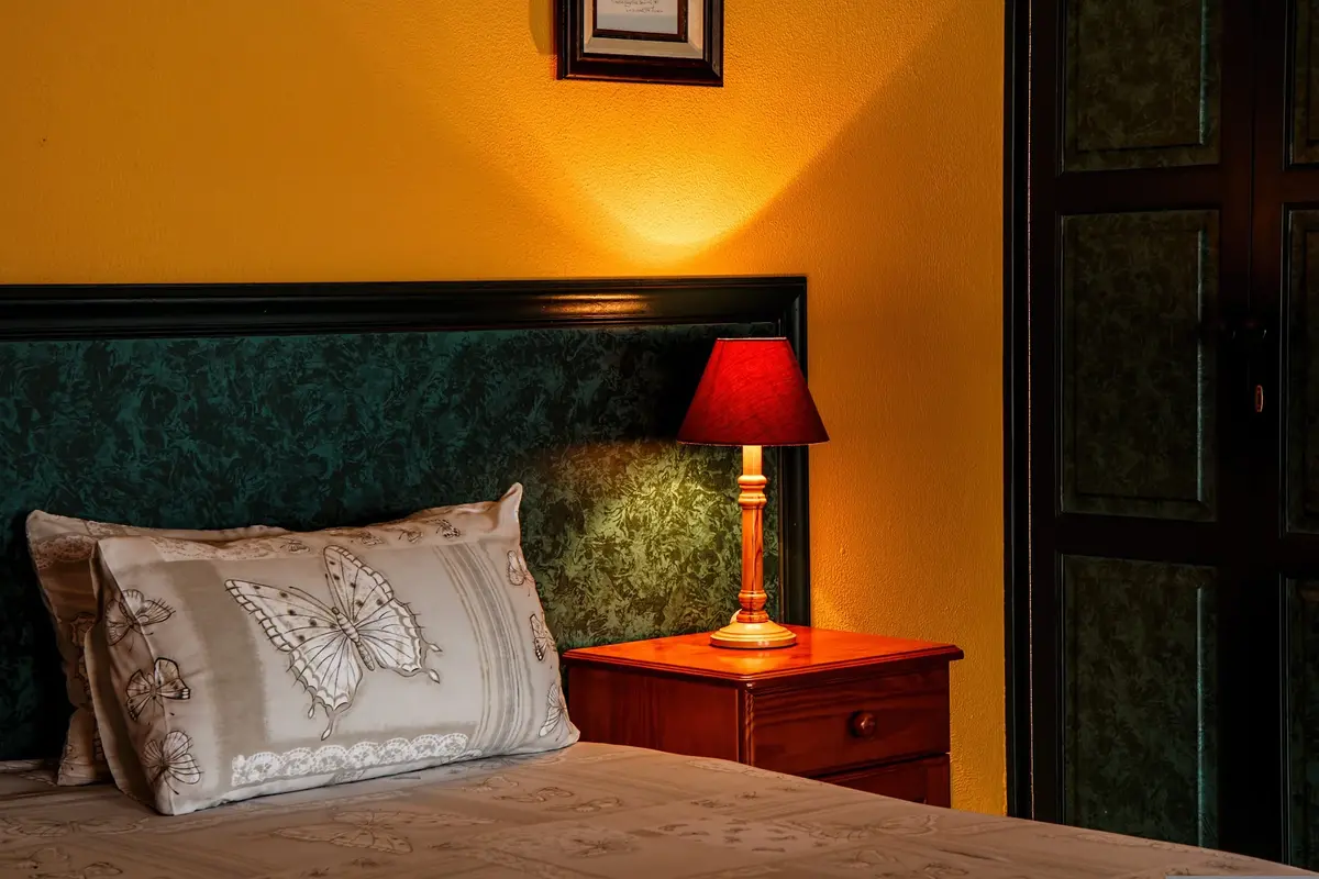 łóżko i lampka nocna stojąca na szafce