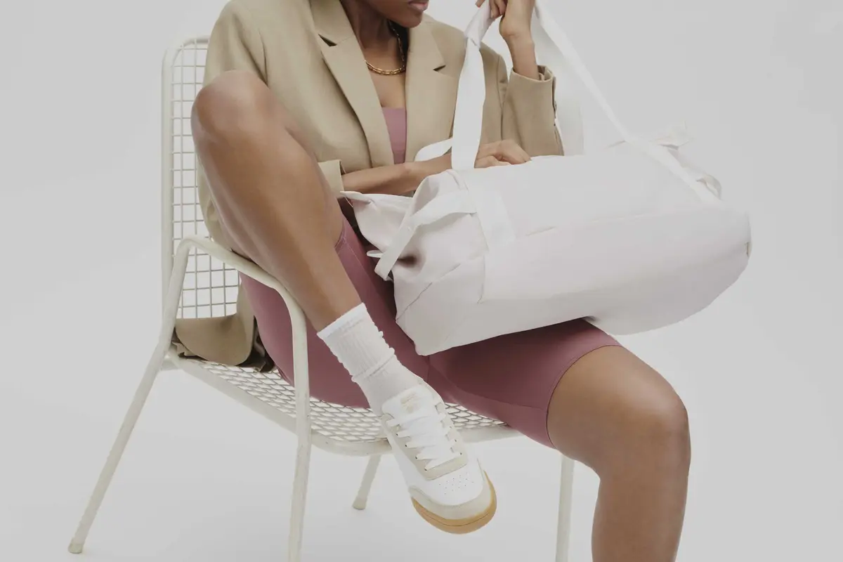 Kobieta w białych adidasach rozparta na krześle