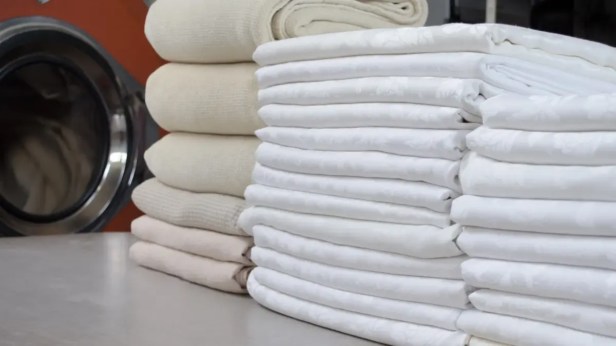 białe pranie obrusy obok stos kremowych tkanin