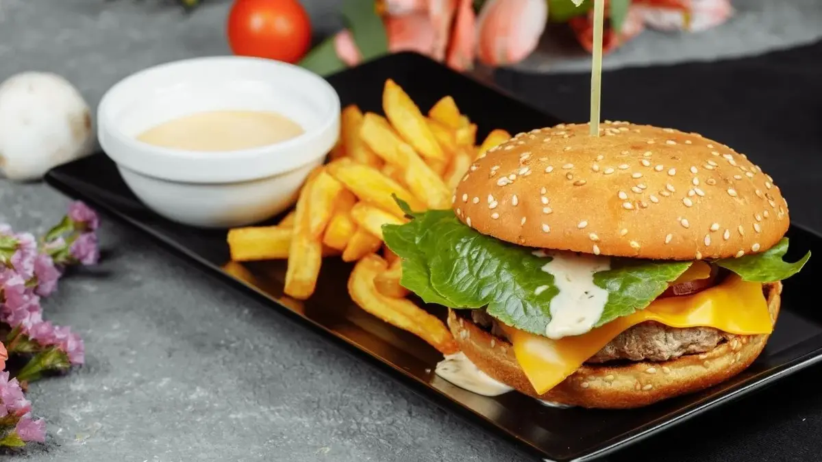 Domowy burger podany z sosem własnej roboty oraz frytkami
