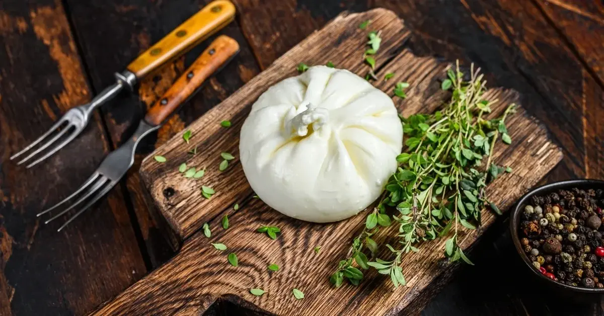 Burrata na drewnianej desce z ziołami