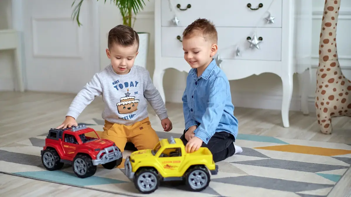 Chłopcy bawią się autkami, które dostali na Dzień Dziecka.