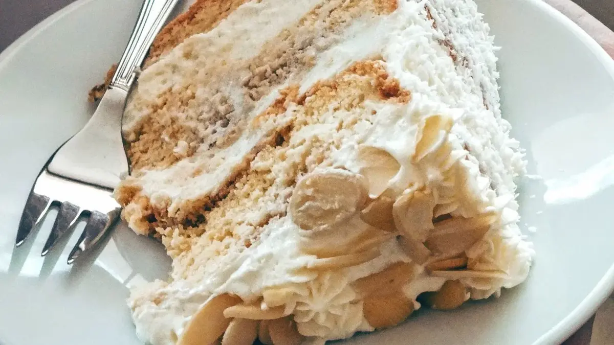 Na białym talerzyku widelczyk i kawałek pysznego ciasta rafaello według przepisu siostry Anastazji