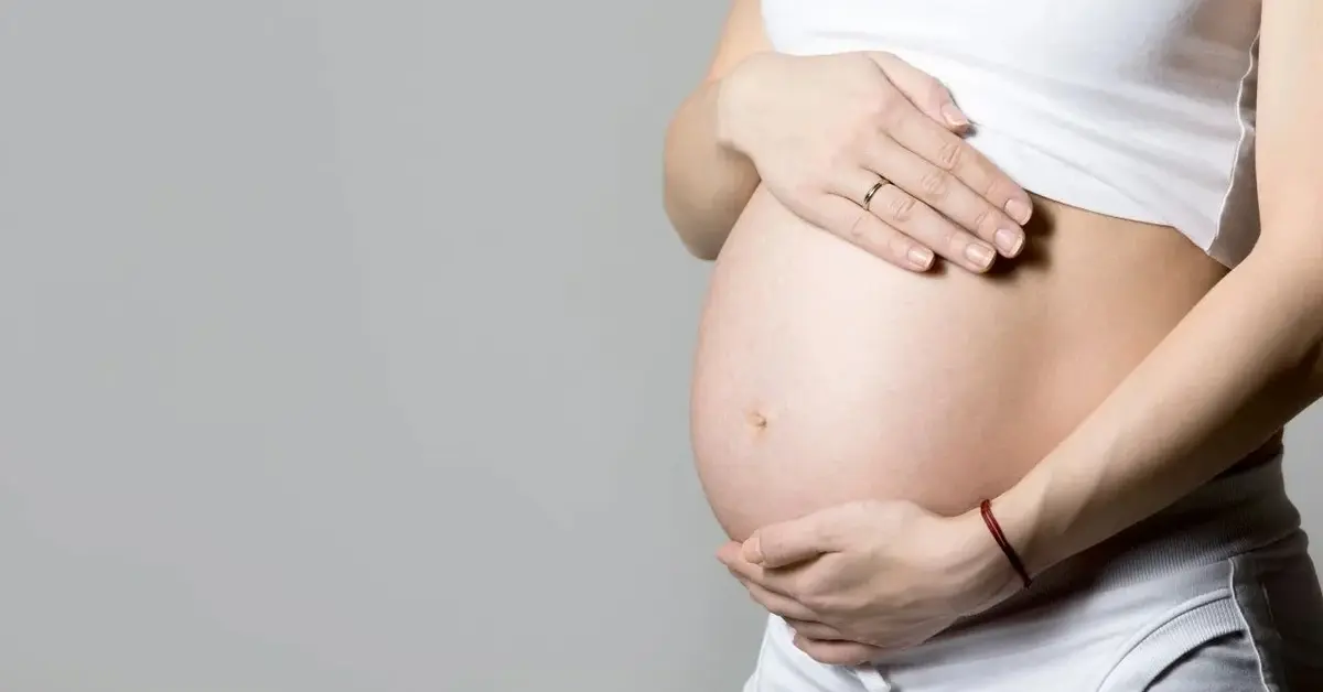 Ciężarna kobieta trzyma się za brzuch