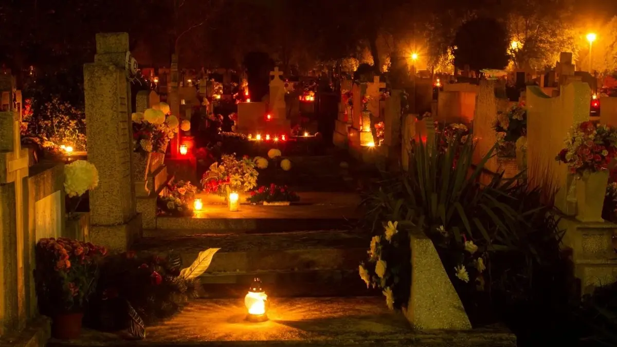 Cmentarz oświetlony nocą na Wszystkich Świętych.
