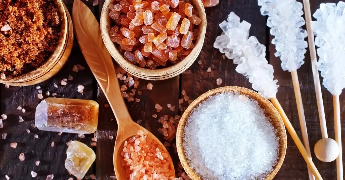 Biały i brązowy cukier leżą na blacie.