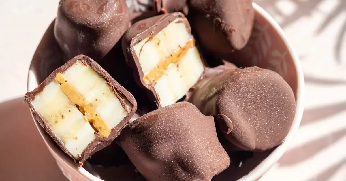 czekoladki z maslem orzechowym w misce jedna przekorojona na pół