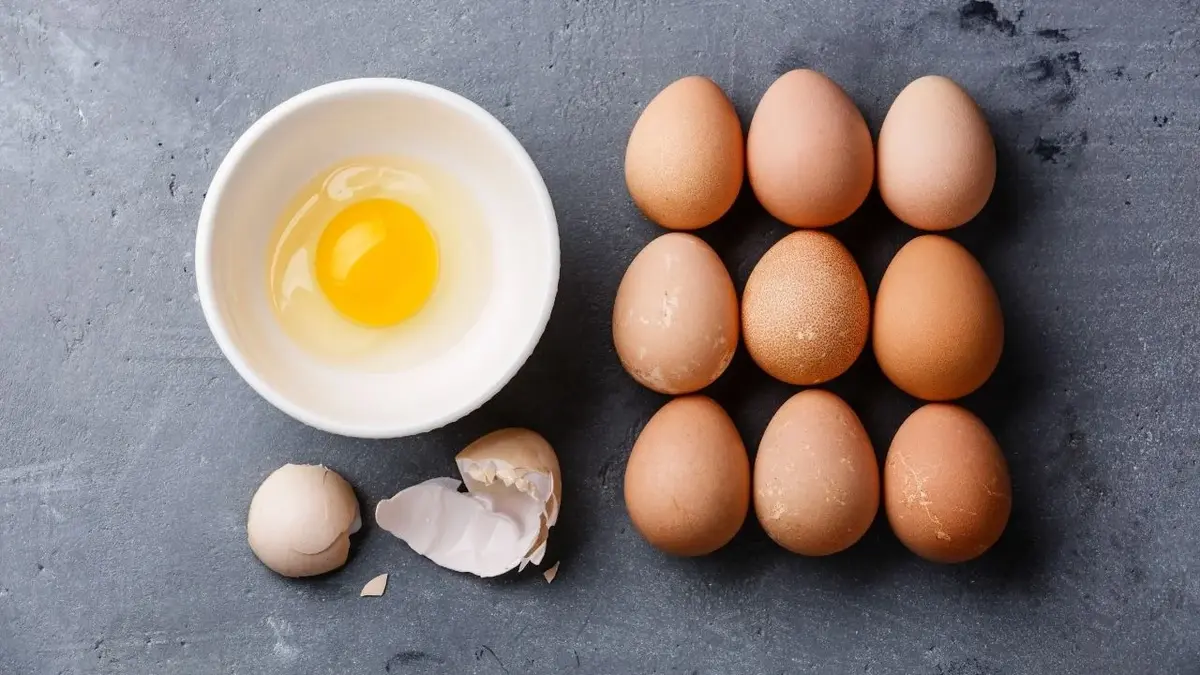 jajka oraz jedno rozbite jajko w białej misce 