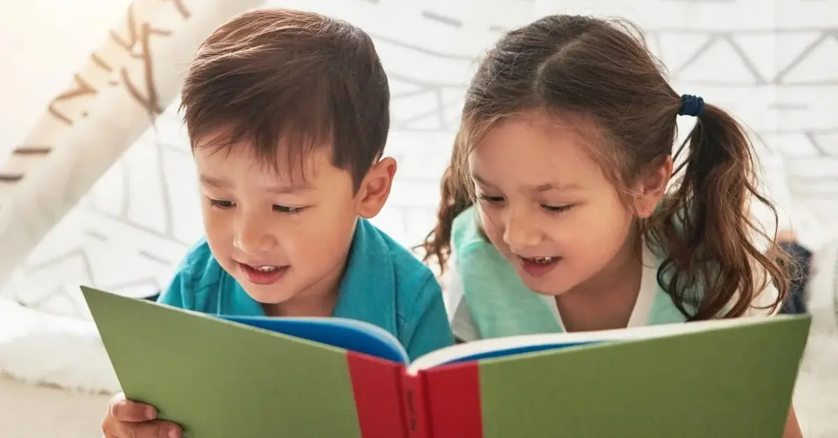 dwójka dzieci czyta książkę