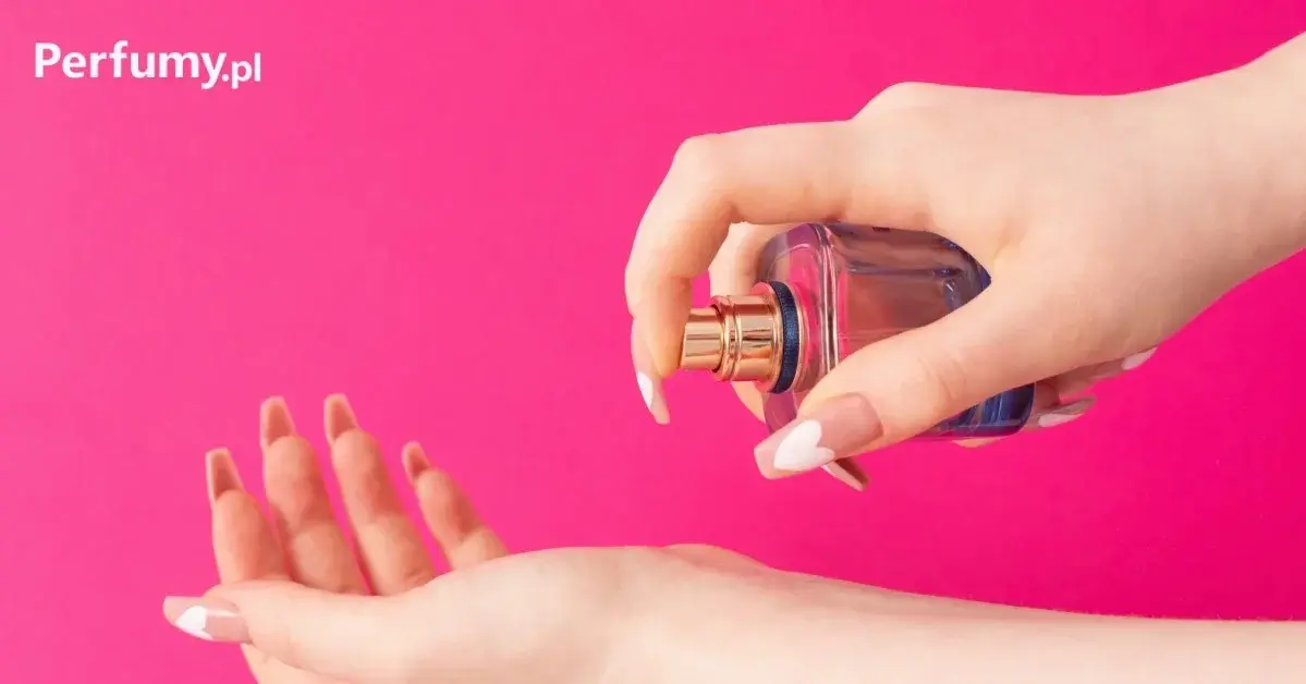 Damskie dłonie, na mocno różowym tle z logo permumy.pl, spryskujące nadgarstek wodą perfumowaną z niebieskiej buteleczki
