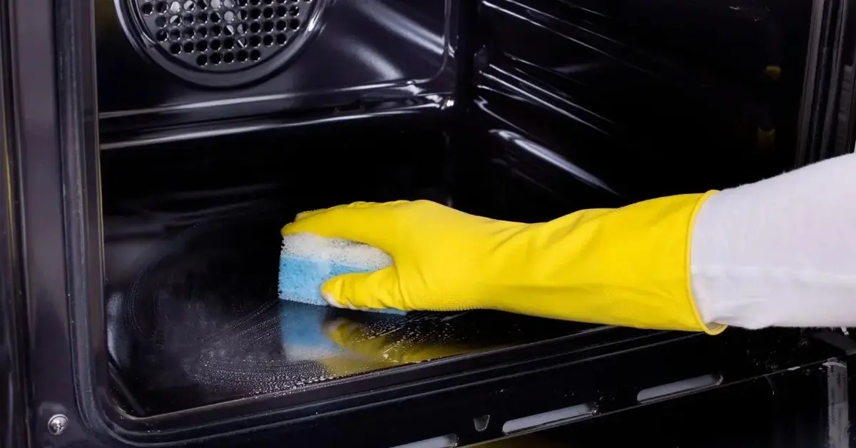 Czyszczenie piekarnika gąbką.