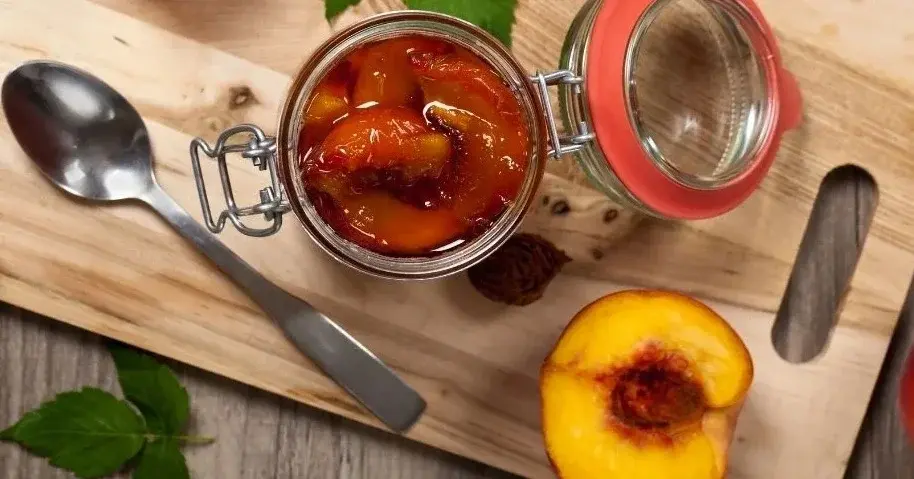 dżem z brzoskwiń z imbirem i rozmarynem w słoiku na desce