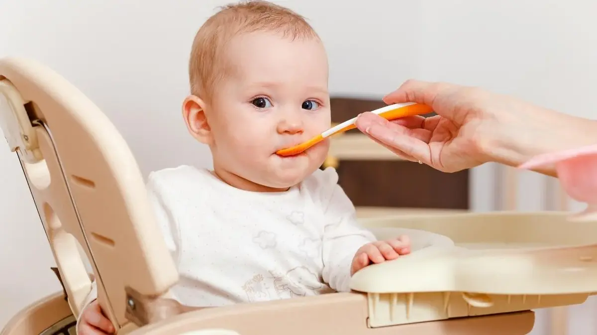 Dziecko w trakcie rozszerzania diety, karmione łyżeczką.