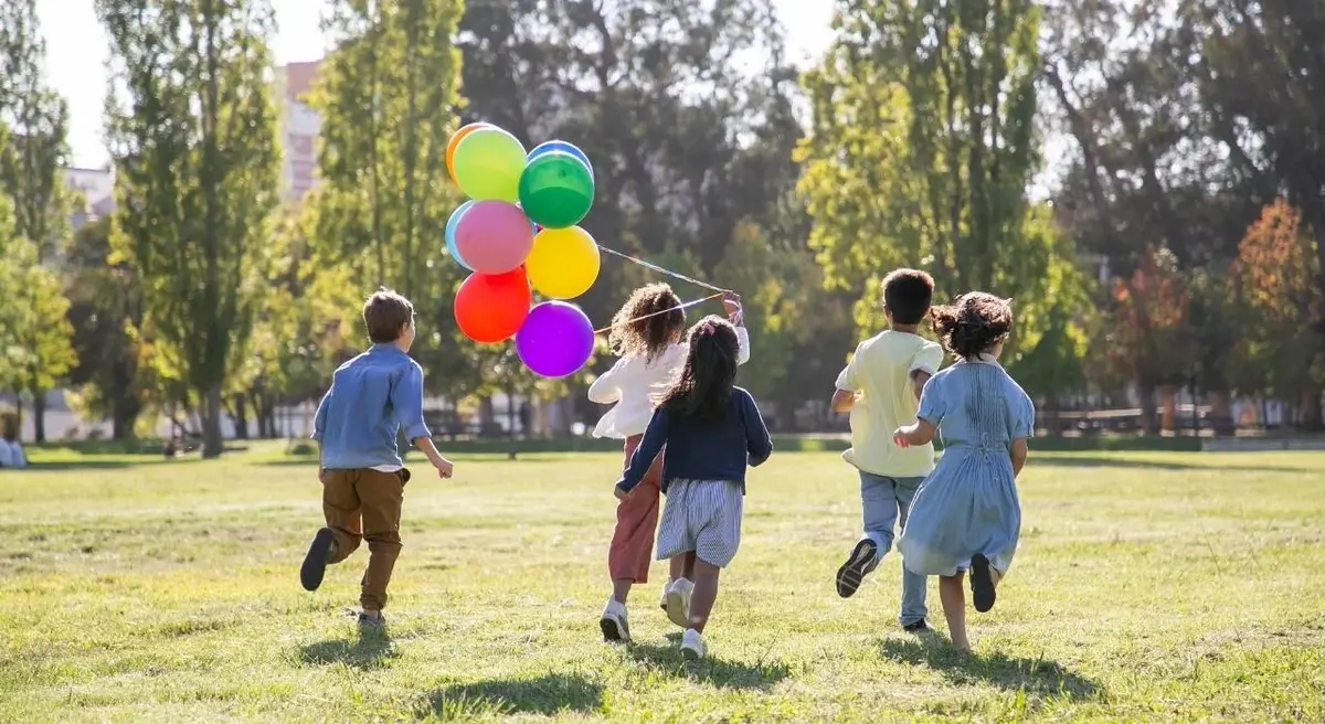 Dzieci biegają po parku w Dniu Dziecka.