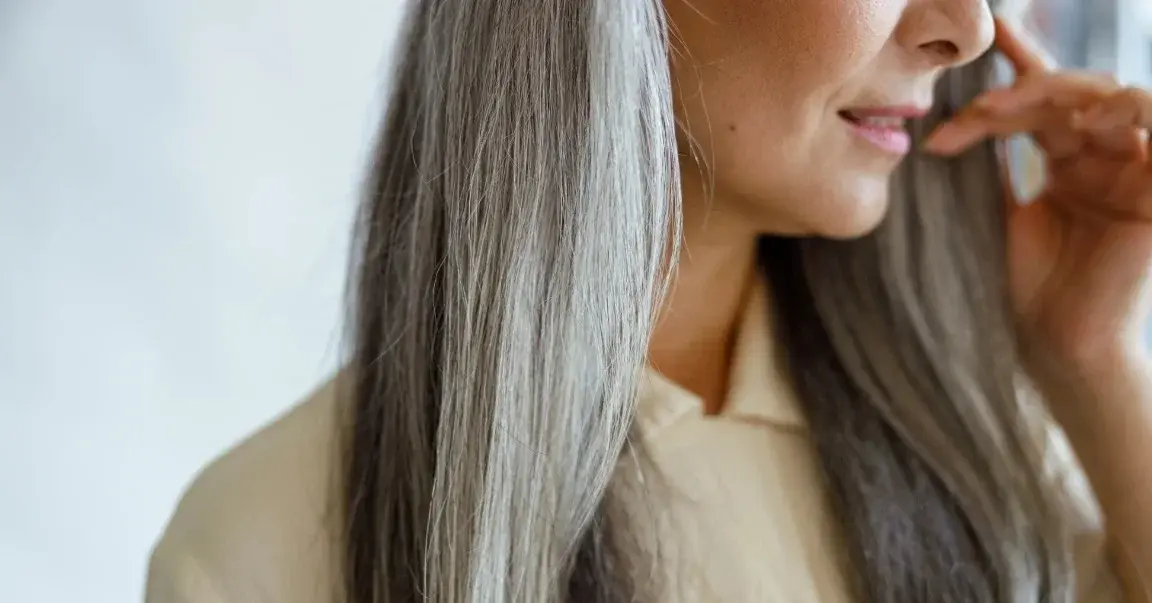 Kobieta o pięknych długich włosach z oznakami siwizny