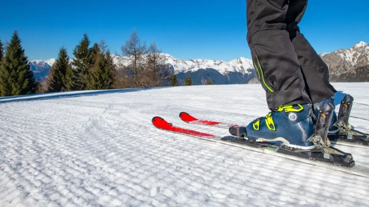 Na dobrze przygotowanym stoku narciarskim nogi narciarza zjeżdzającego w dół