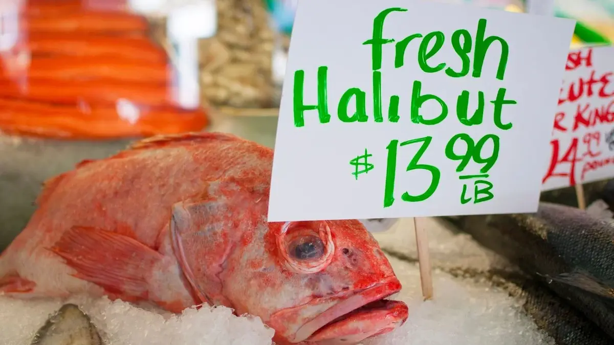 Świeża czerwonego koloru ryba na straganie z lodem z kartką o cenie halibuta