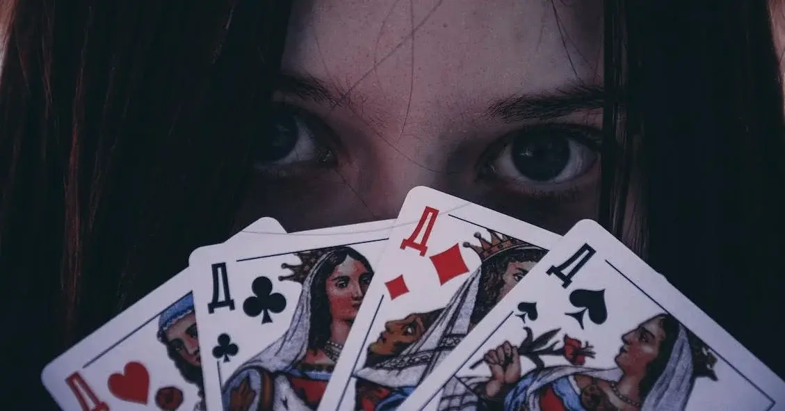 Kobiece oczy spoglądające ponad talią kard w trakcie gry hazardowej