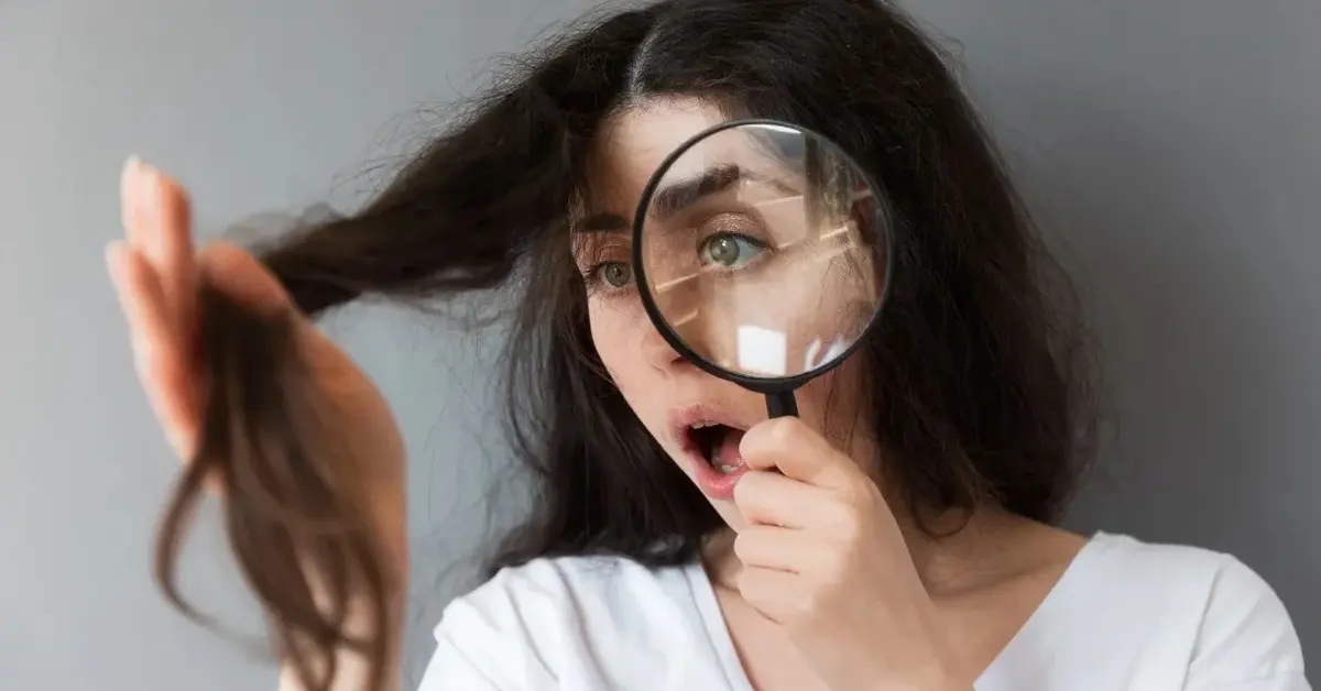 Kobieta patrząca na kosmyk włosów przez szkło powiększające 