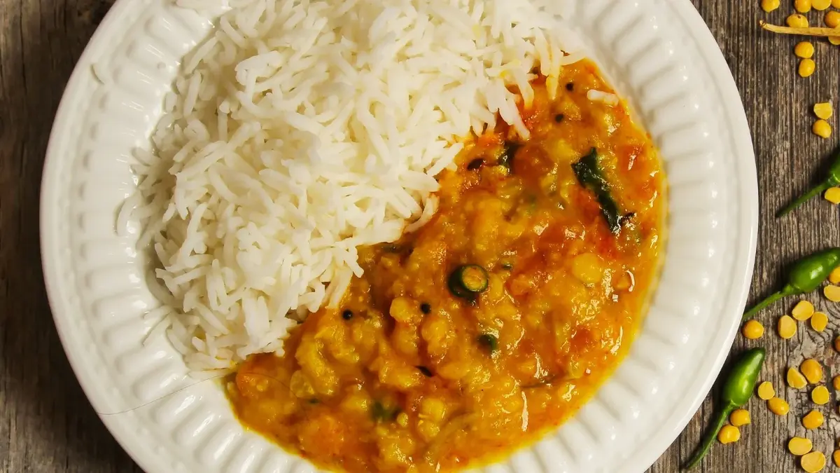 Curry z cukinią i ryżem na papierowym talerzyku 
