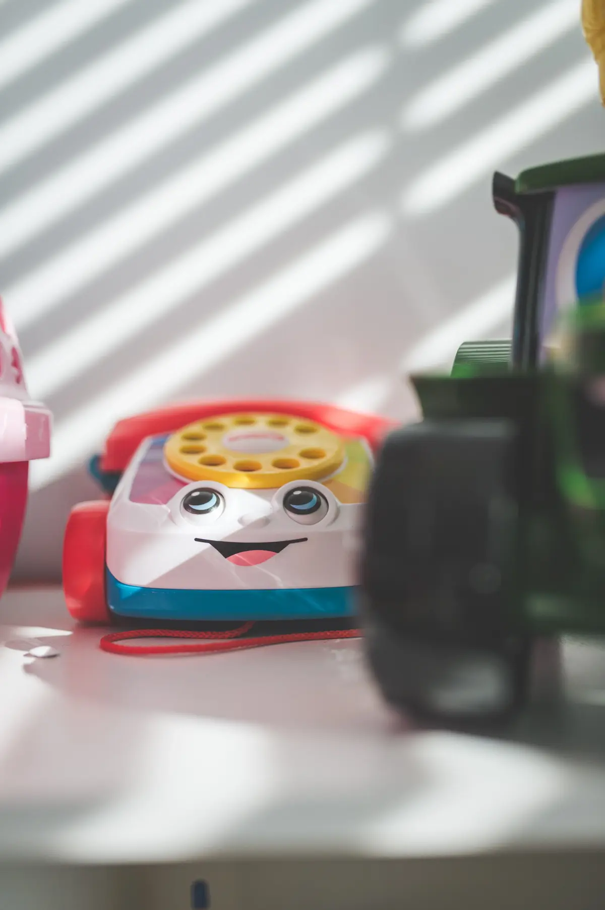 Zabawka kolorowy telefon w pokoju dziecięcym na tle białej ściany