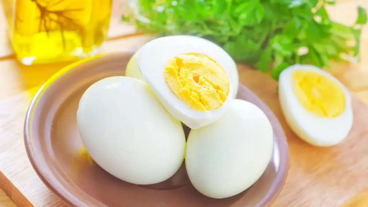 Jajka na twardo przeznaczone do diety jajecznej. W tle zielenina.