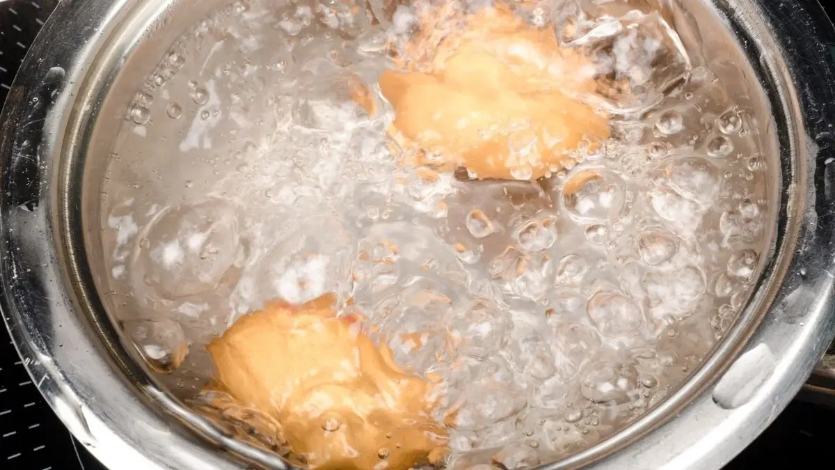 Rondel pełen wrzącej wody z gotującymi się jajkami na twardo