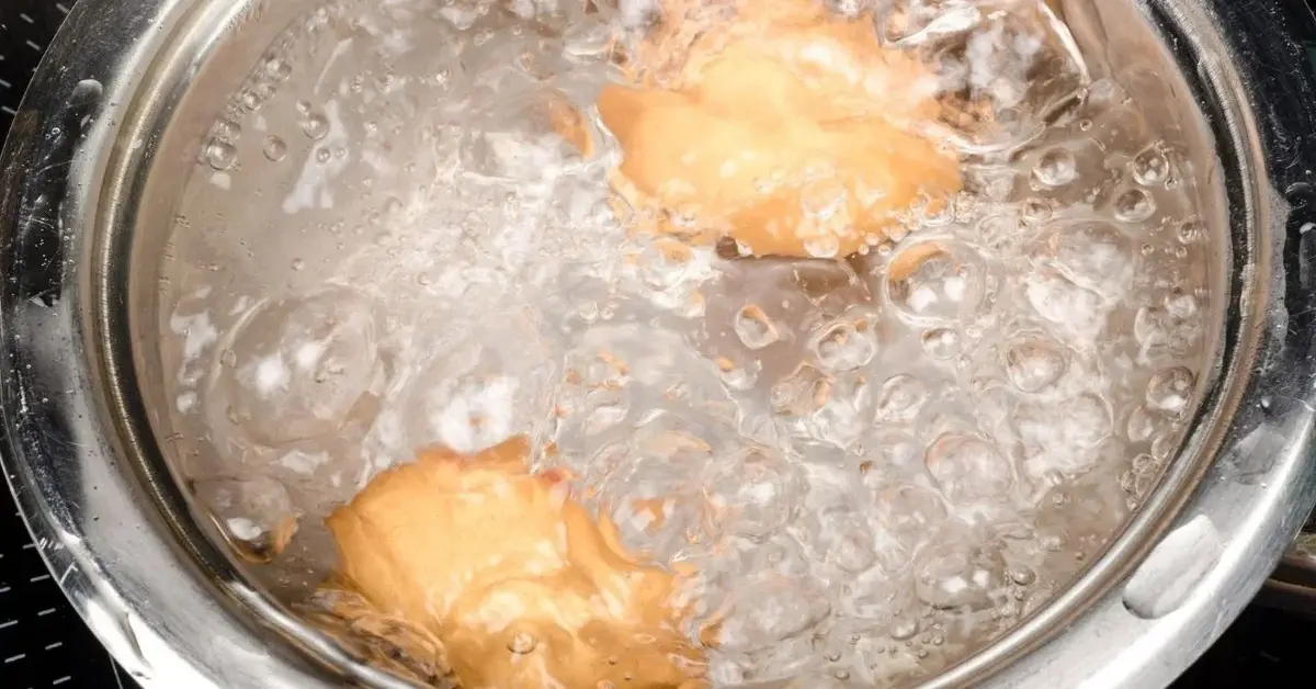 Rondel pełen wrzącej wody z gotującymi się jajkami na twardo