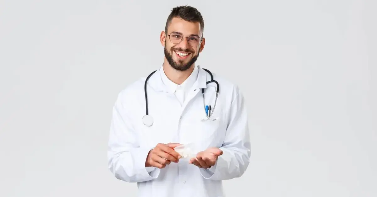 Uśmiechnięty lekarz w białym kitlu ze stetoskopem na szyi