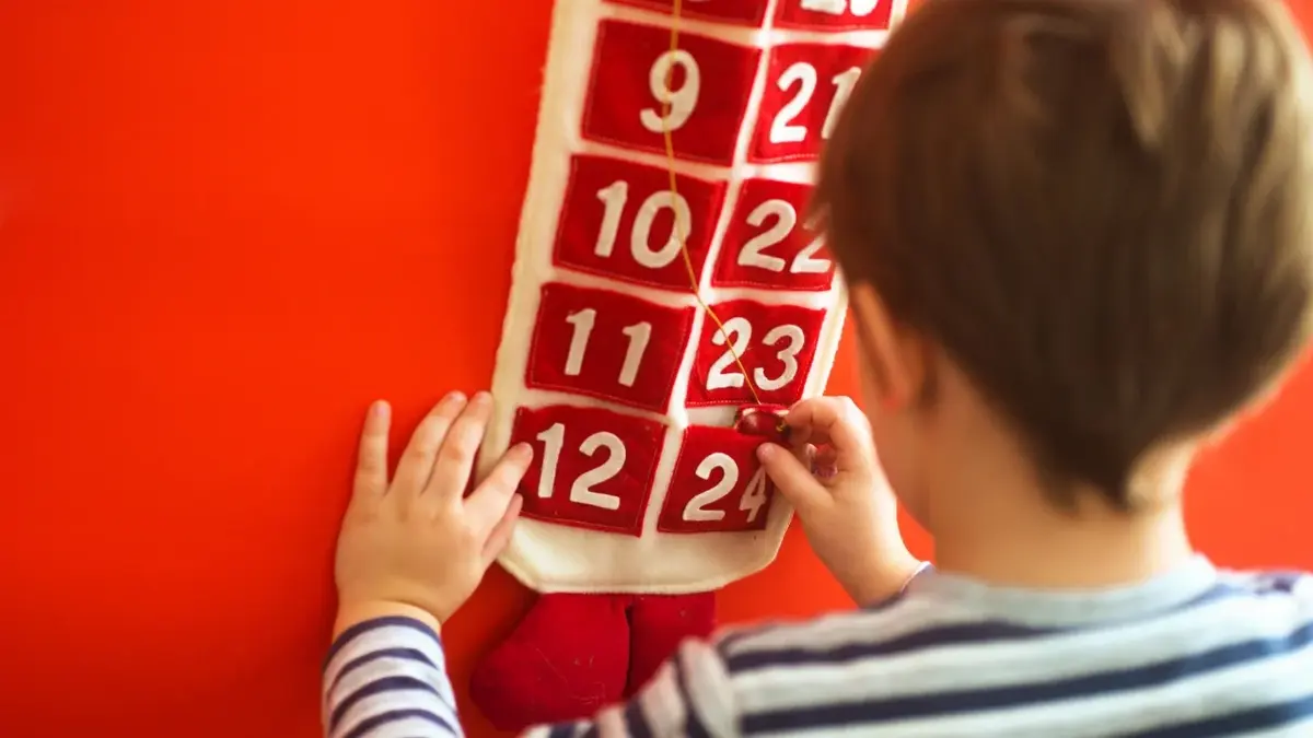 Dziecko wyjmuje zadania z kalendarza adwentowego.
