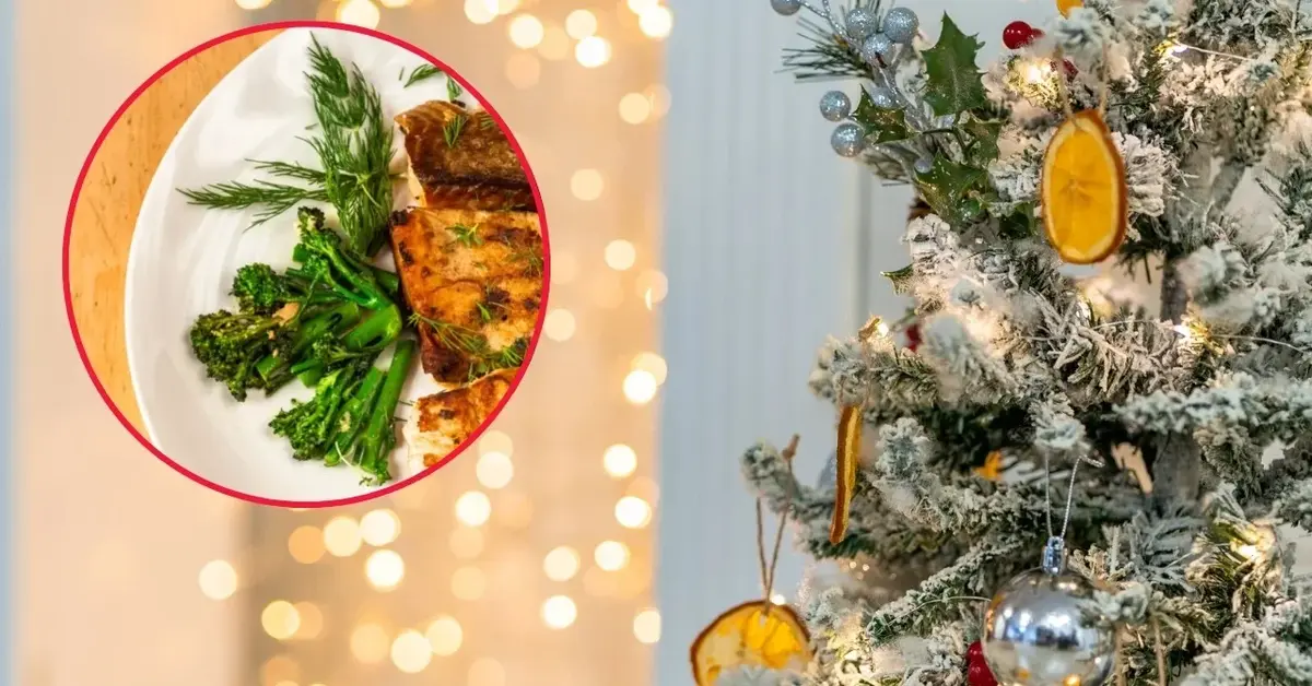 Wigilijny pieczony karp na tle choinki.