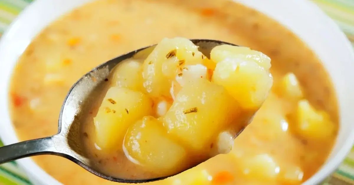 zupa kartoflanka na łyżce, pod spodem miska z zupą