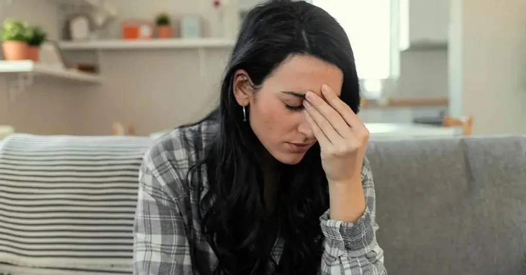 Kobieta ma atak paniki i siedzi na kanapie.