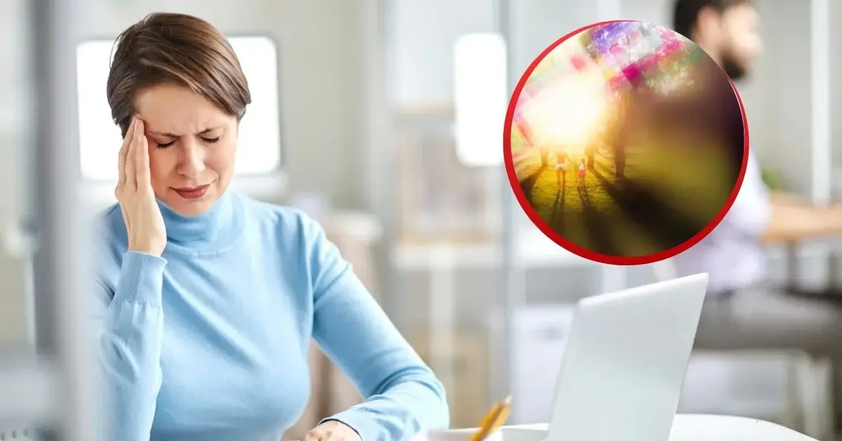 Kobieta trzyma się za głowę, bo ma migrenę z aurą.
